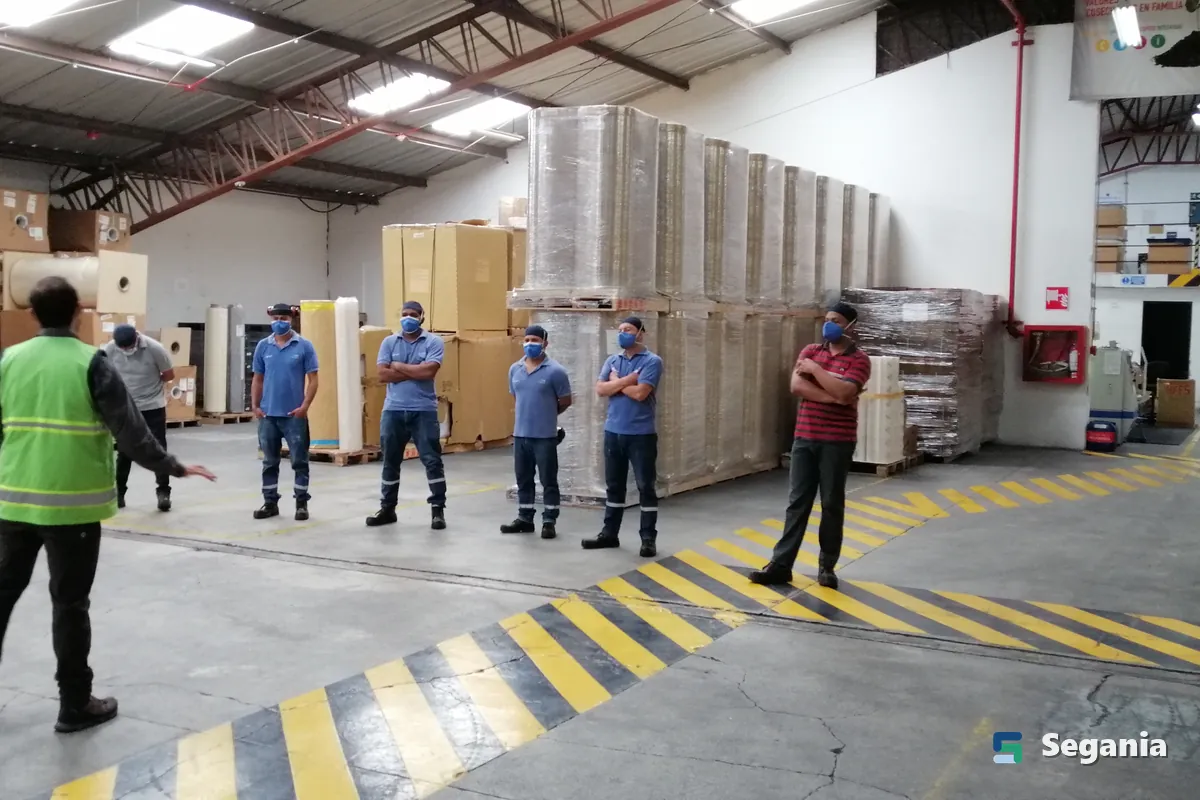 Charla de seguridad a un grupo de trabajadores en una bodega