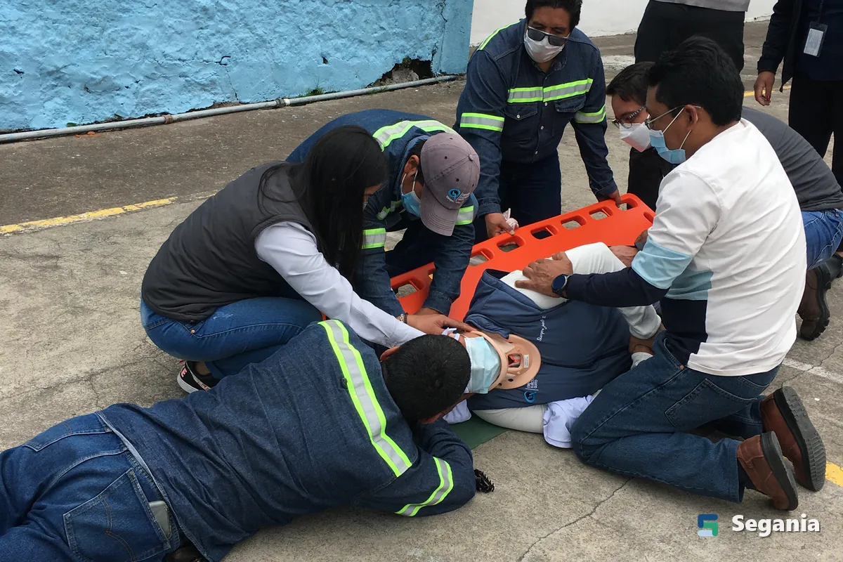 Equipo inmovilizando a una persona sobre una camilla rígida